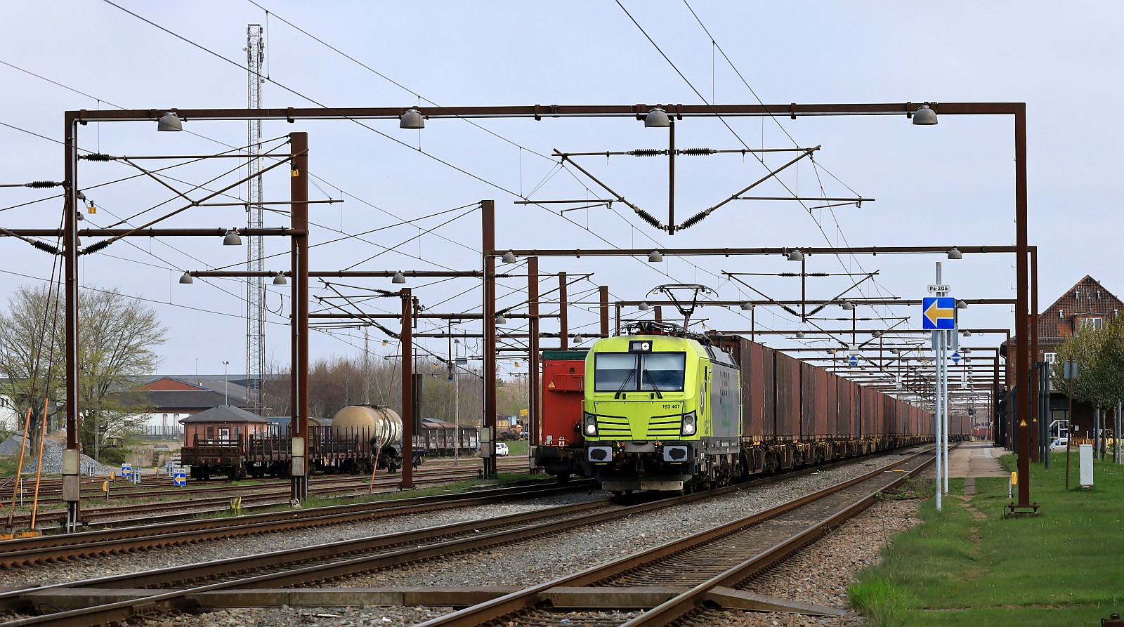 ATLU/GreenCargo 193 407-4 wartet mit der  braunen Wand  dem Volvo-Zug auf Ausfahrt im Bhf Pattburg/DK. 24.04.2026 